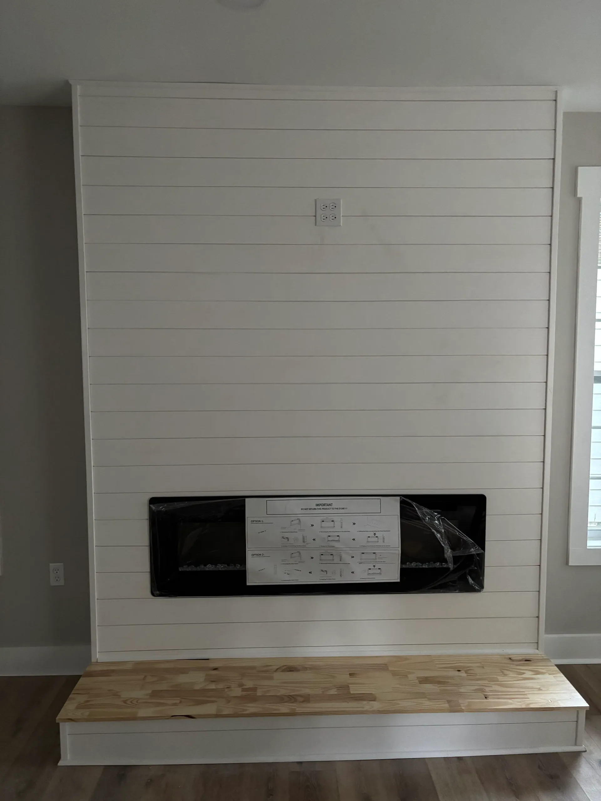 Shiplap accent wall with fireplace insert and hearth
