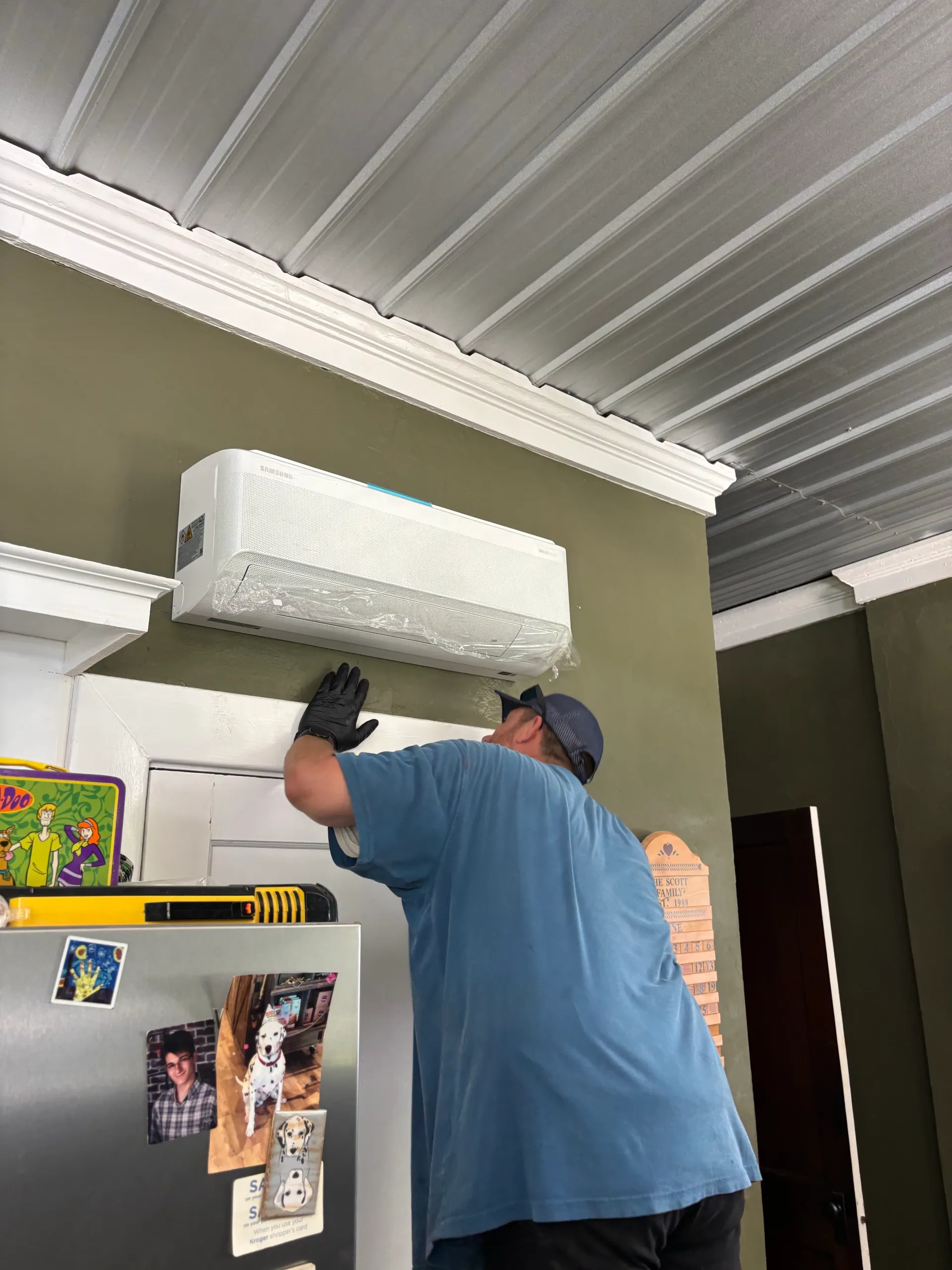 Ductless wall-mounted indoor head being installed by a technician